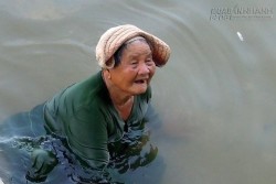 Xót xa bà cụ ngâm mình dưới nước mò ốc nuôi cháu