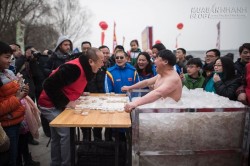 Người đàn ông gấu bắc cực đứng trong thùng đá lạnh chơi cờ