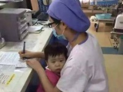 Nữ y tá vừa bế trẻ mồ côi vừa làm việc gây xúc động